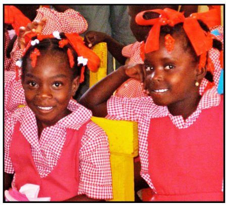 Two Haitian school girls dressed in colorful uniforms