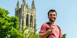male student standing outside in front of barbelin hall