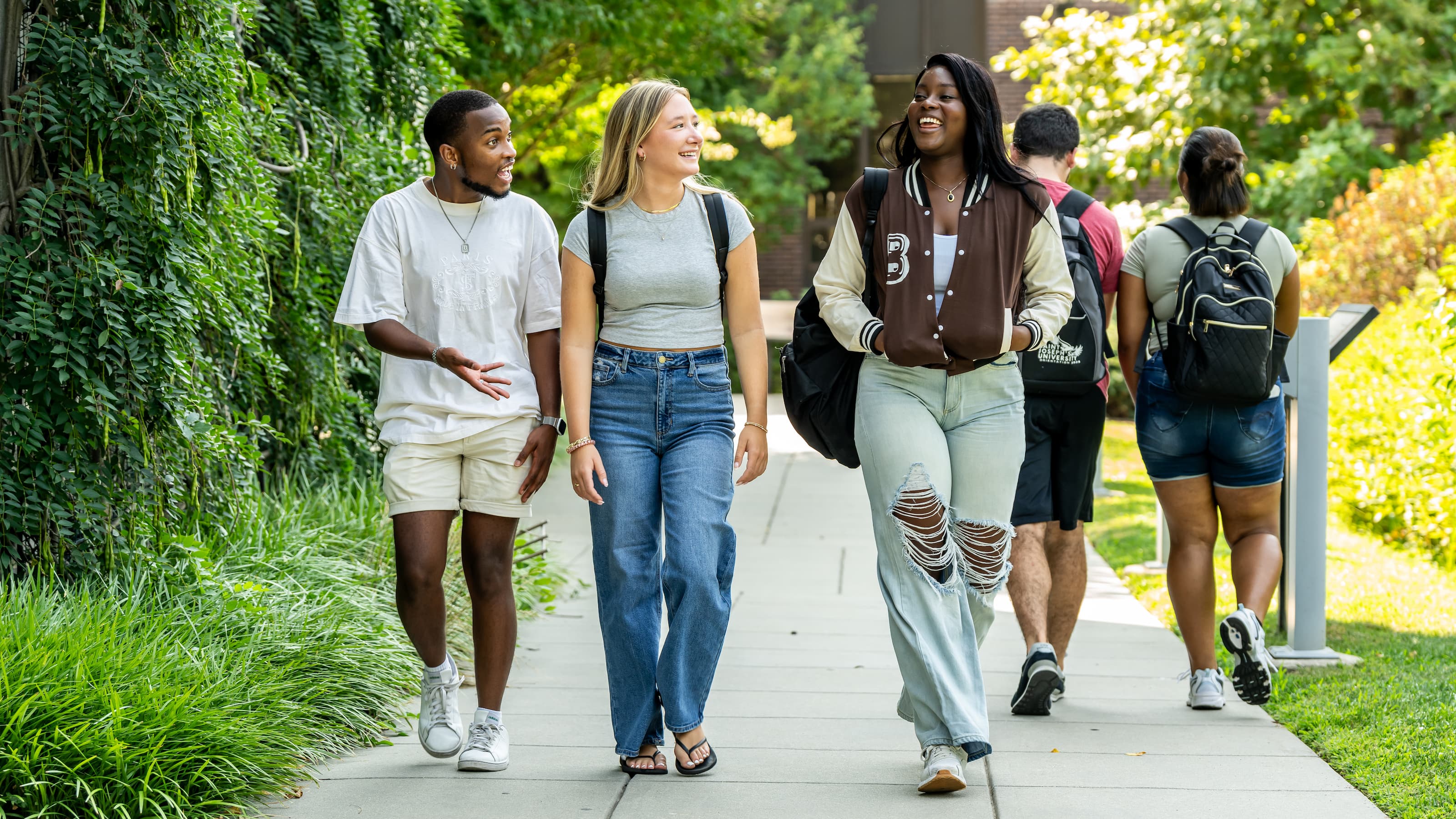 SJU students conversing as they walk through campus.