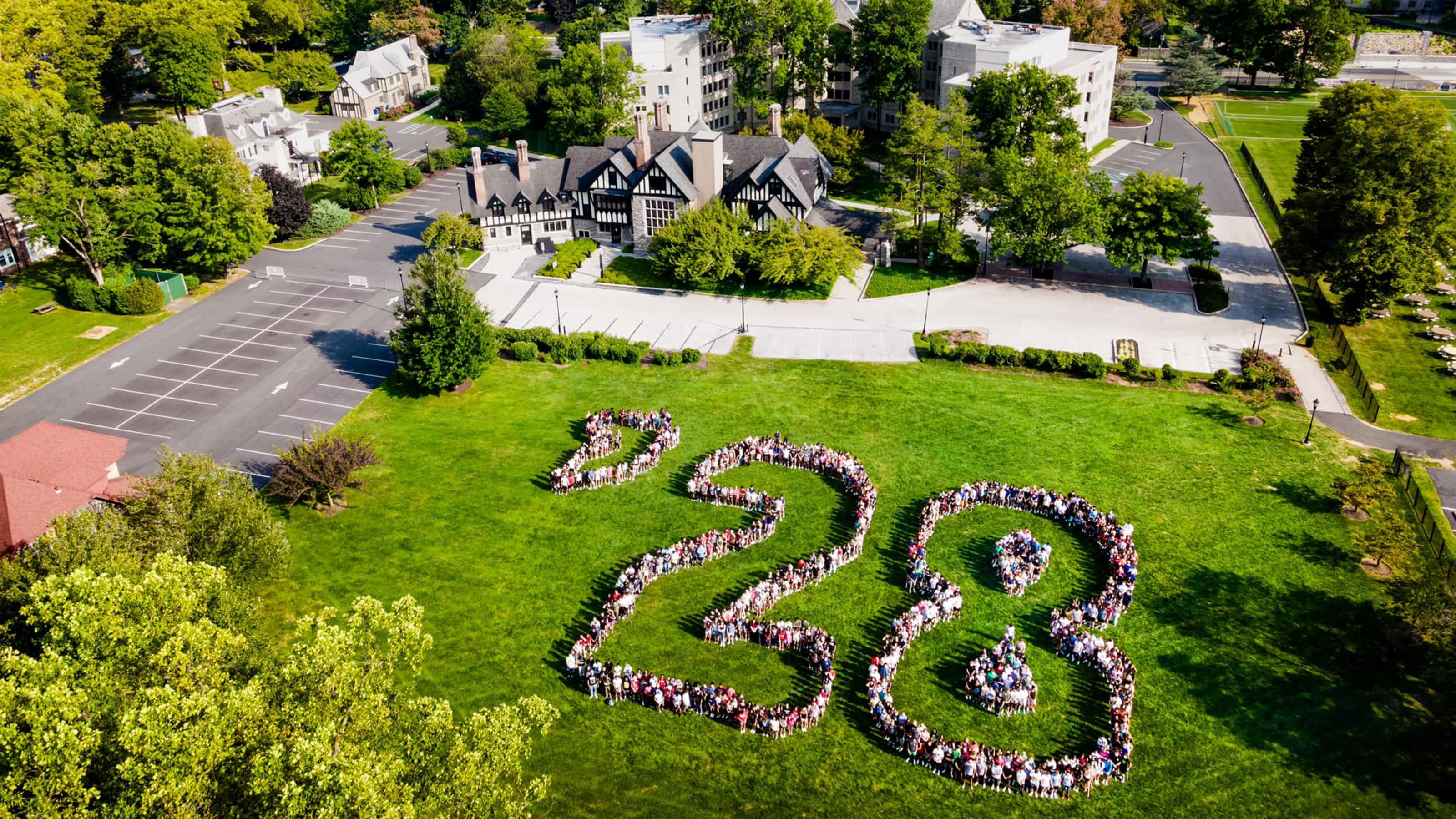 Aerial photo of students standing in formation outlining '28 on a grassy field