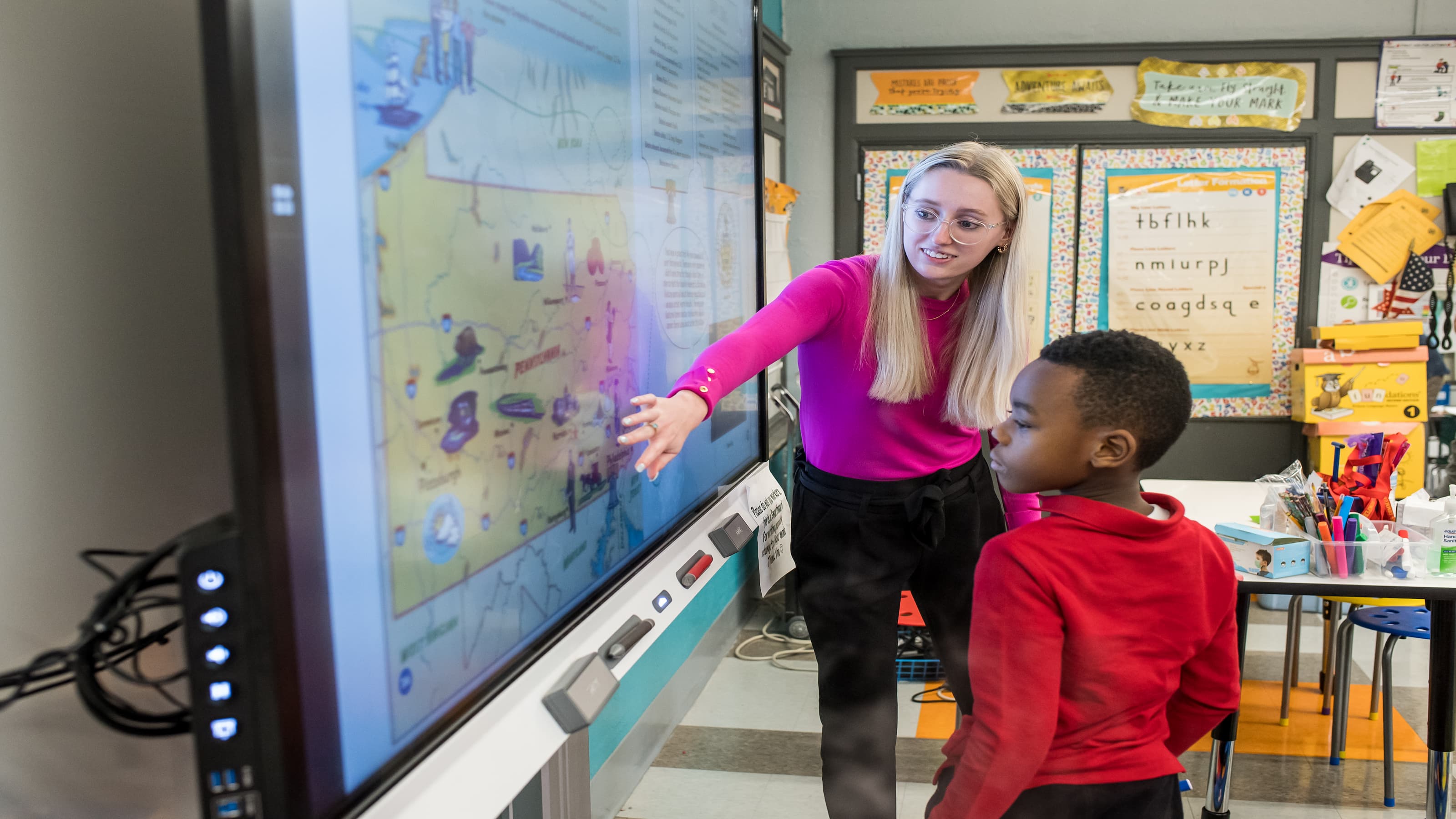 An SJU student teaches an elementary student at Gompers Elementary. 