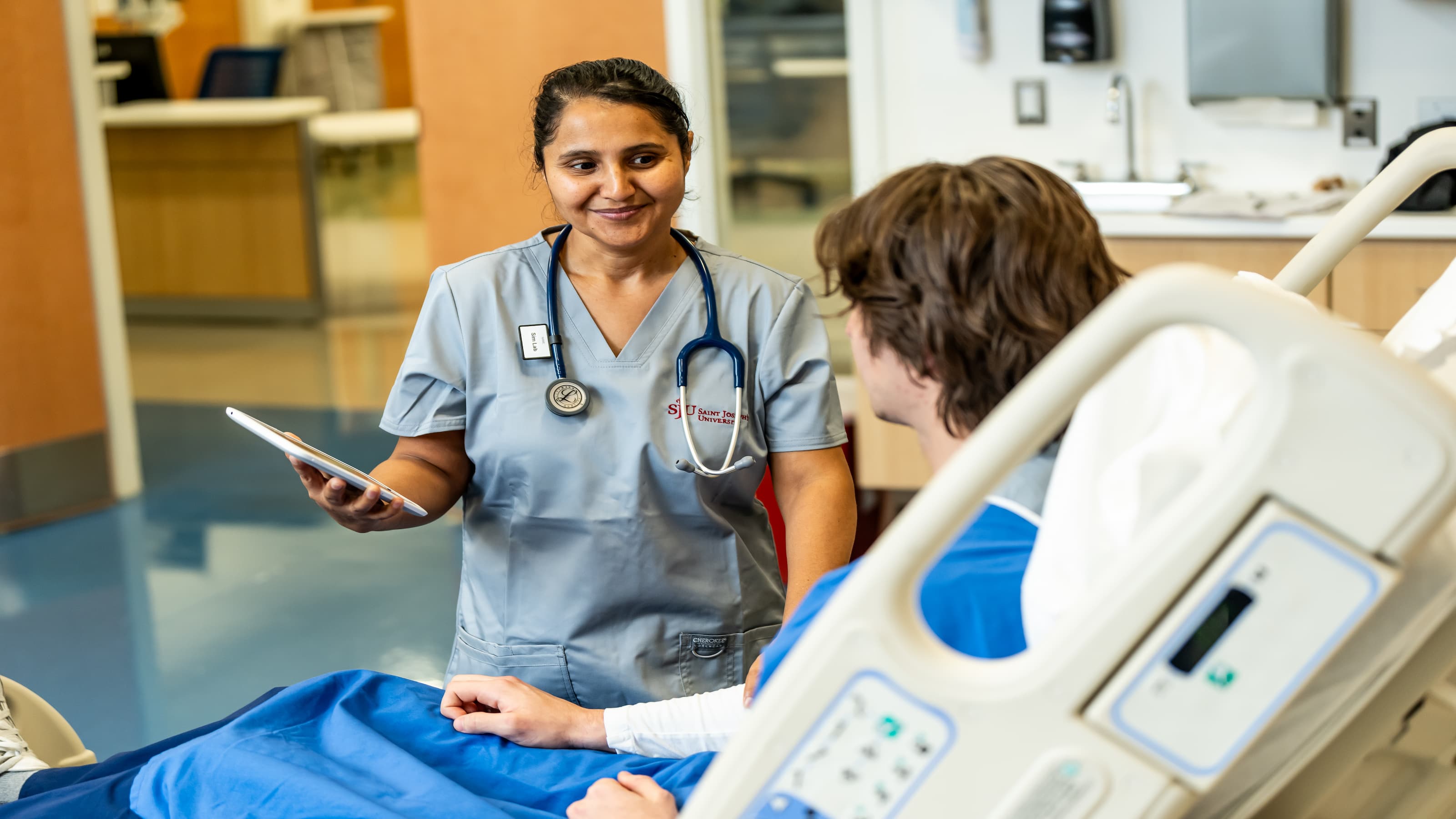 An SJU nursing student conducts an examination on a patient simulator. 