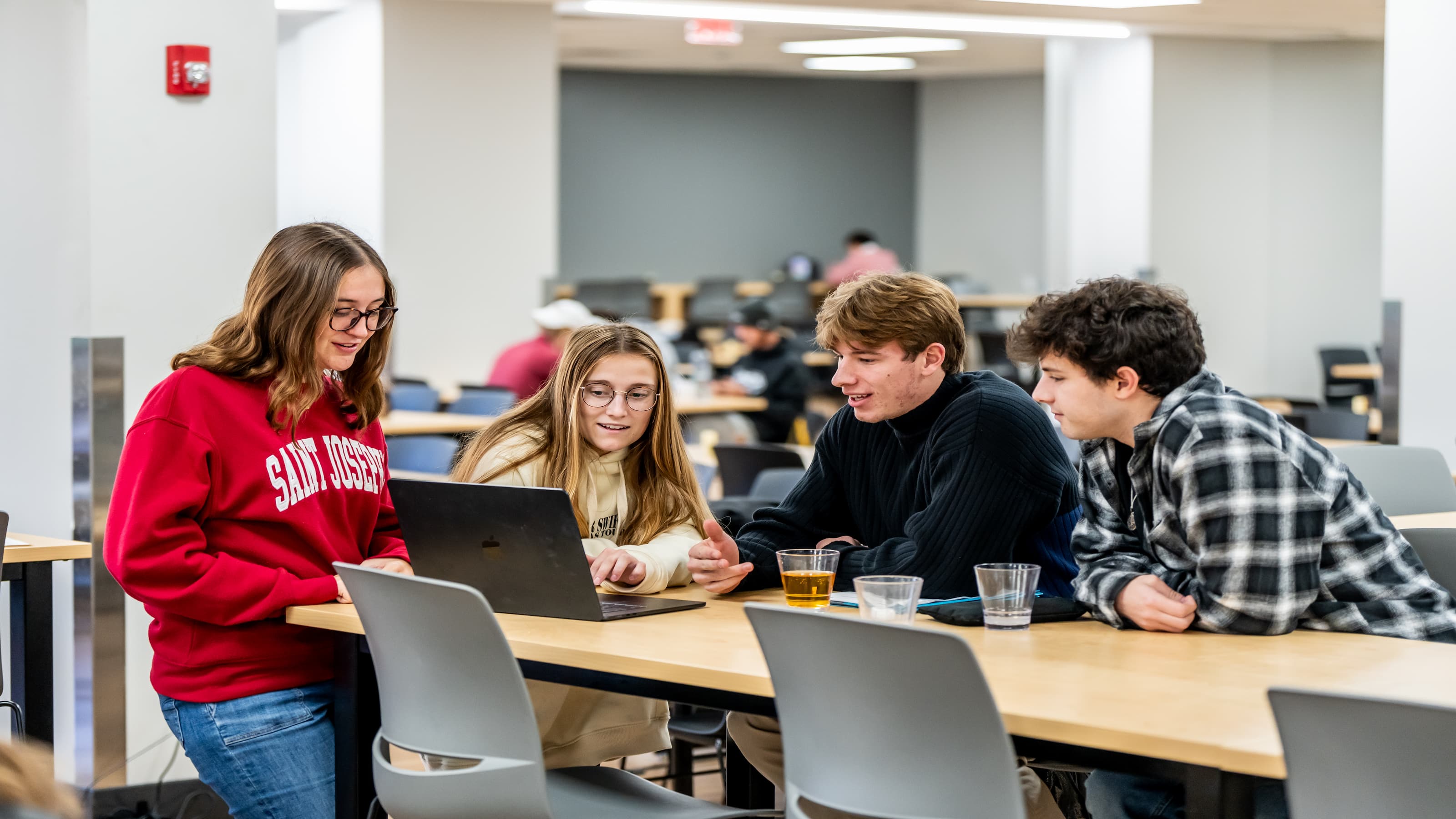 A group of students converse in the Kettle. 