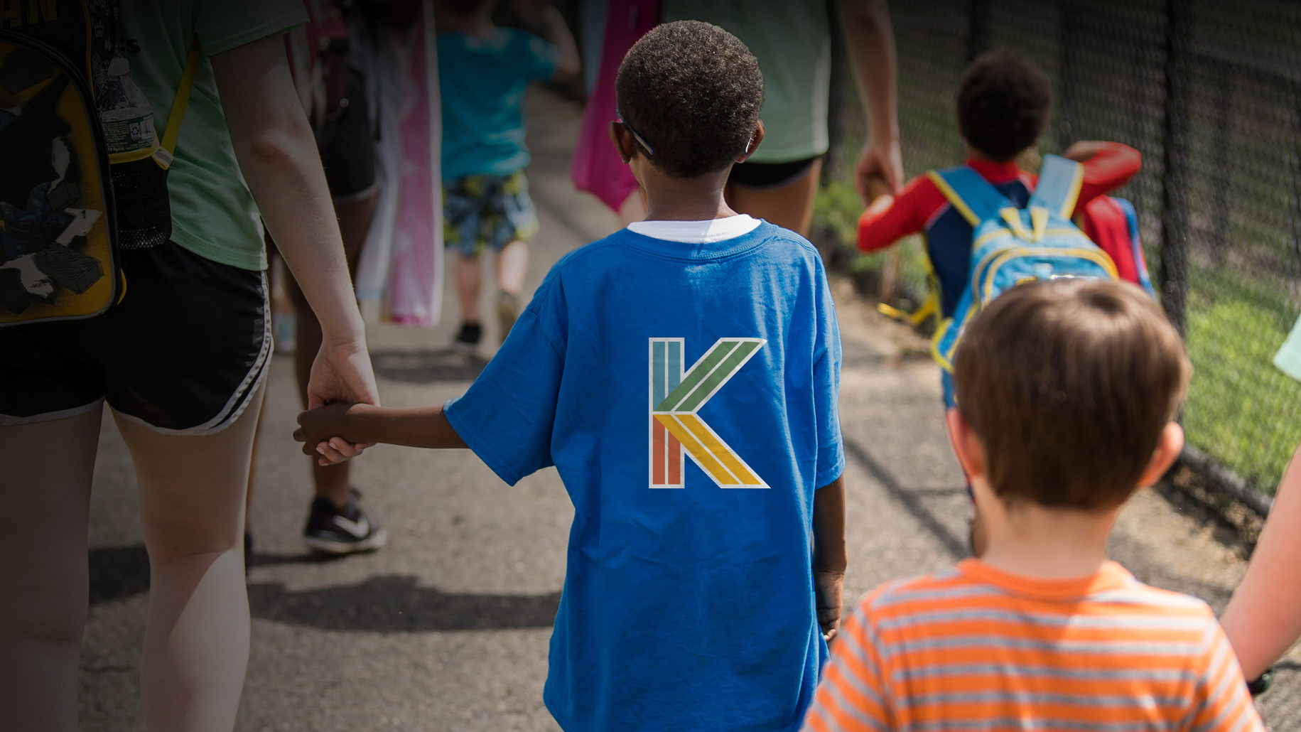 Young student wearing blue shirt with Kinney logo on the back