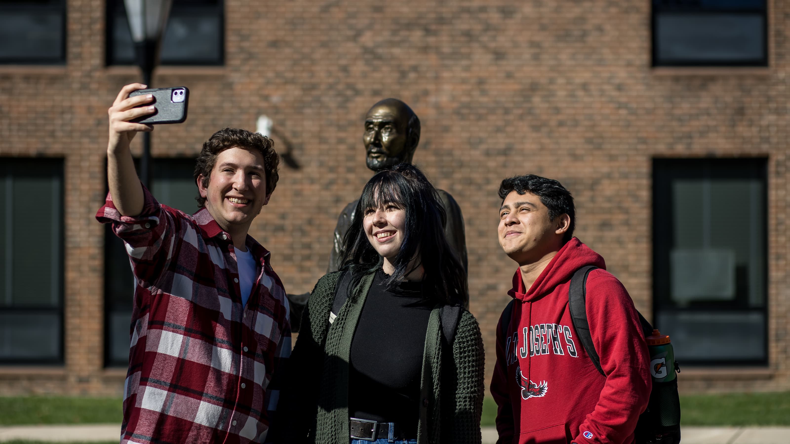 Smiling students taking a selfie outside the Merion