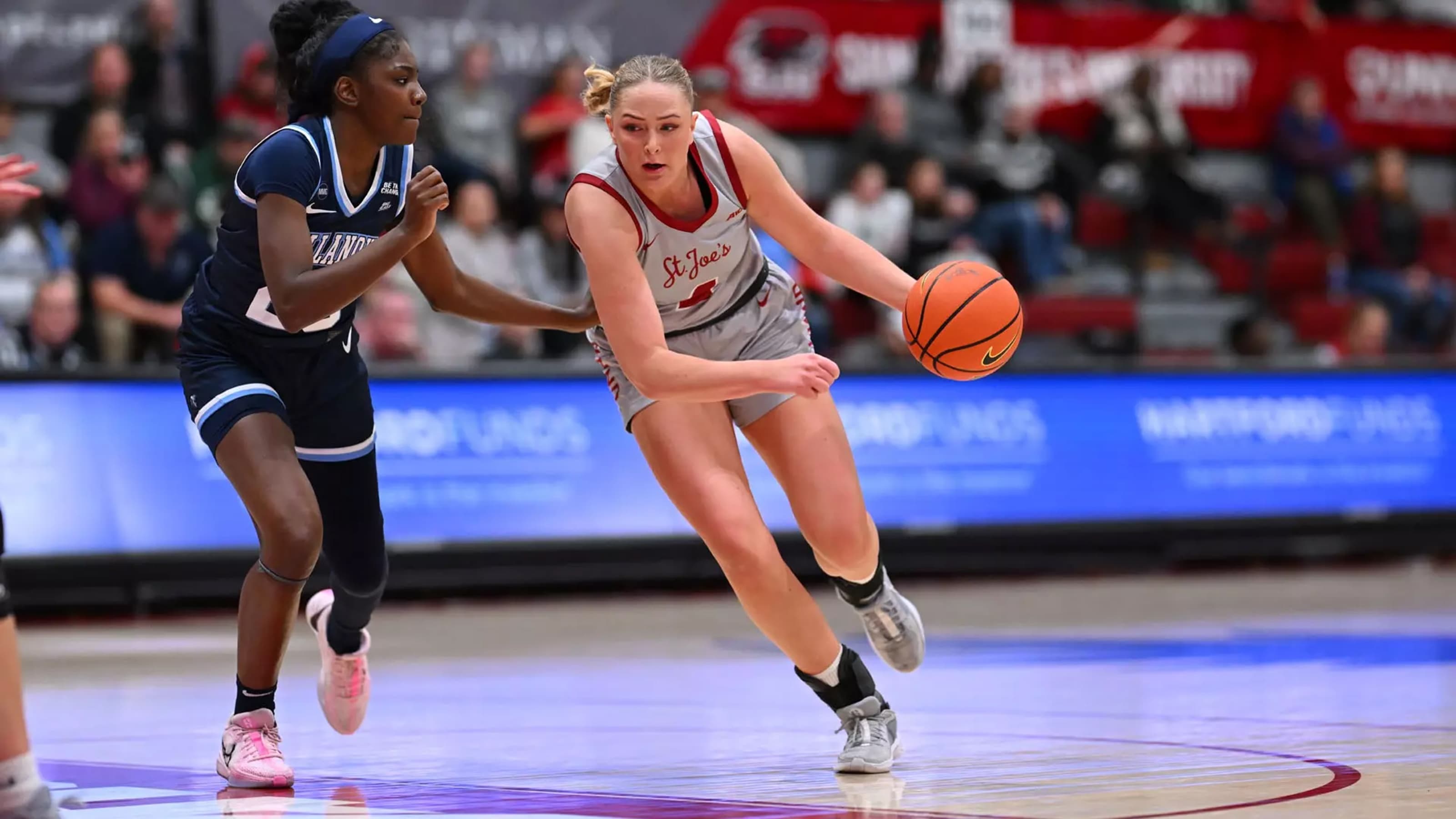 Laura Ziegler running on court with basketball in hand against opponent