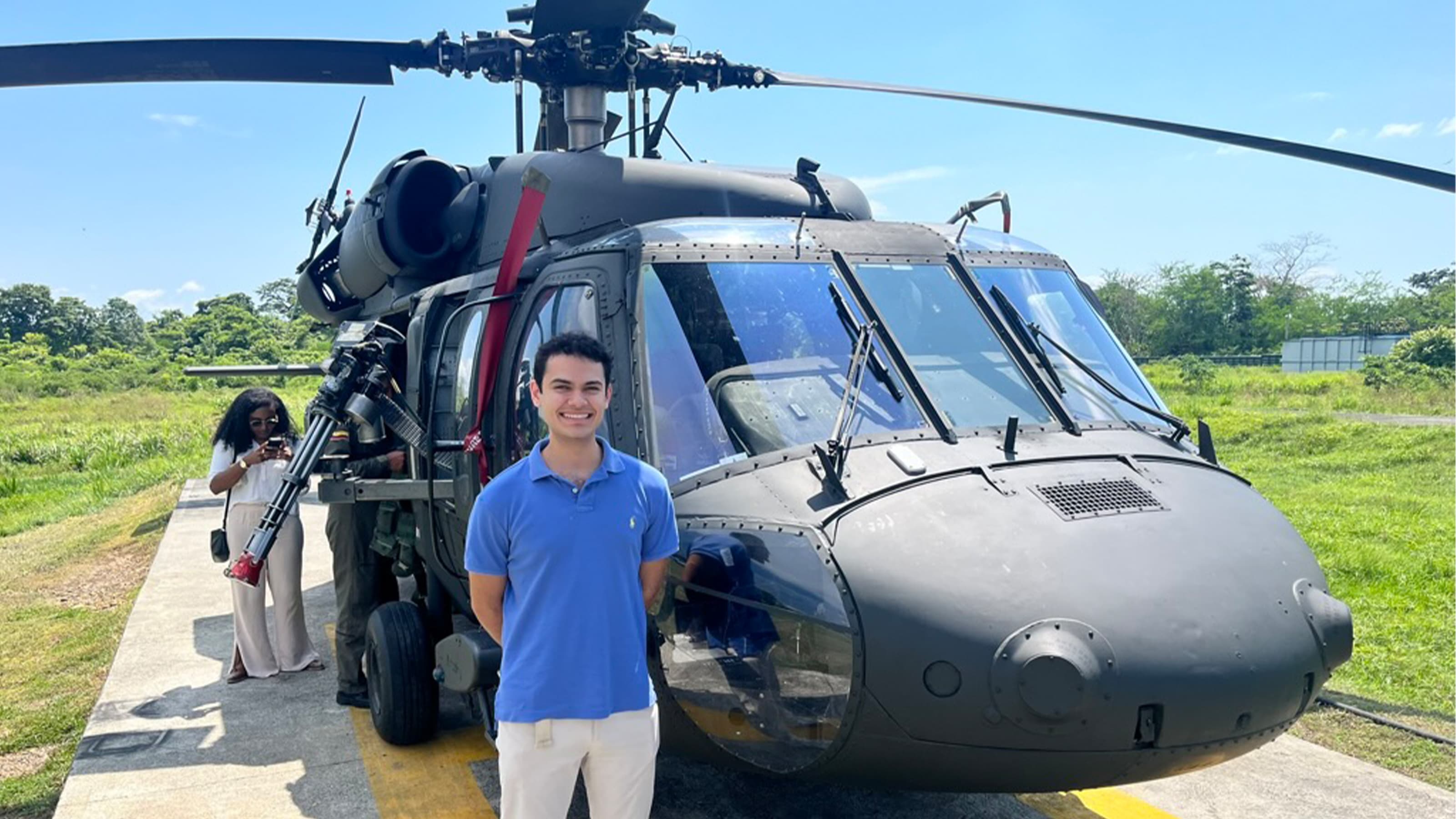 Caleb Datto standing in front of a helicopter 