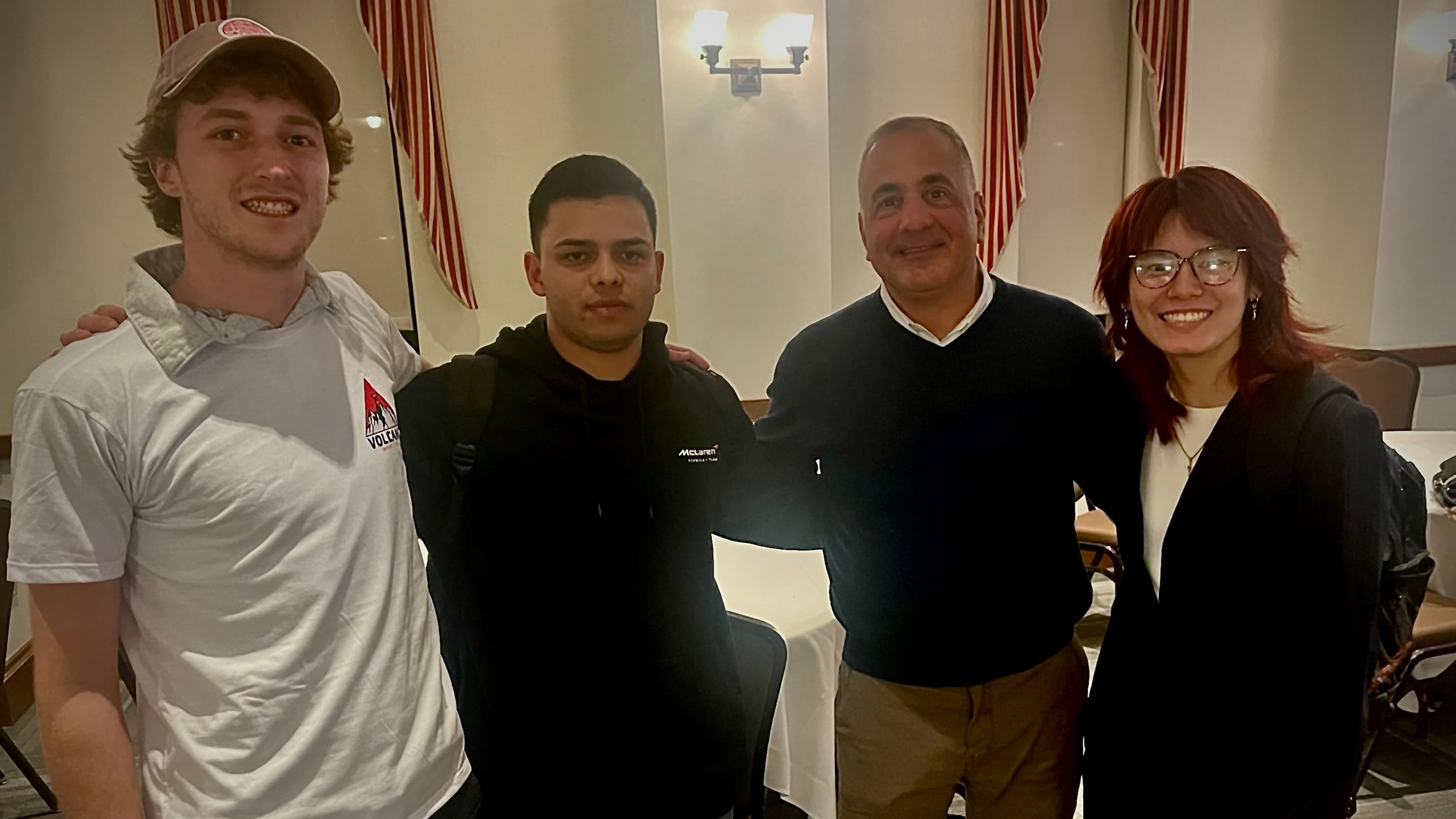 Bill Nicoletti posing with three student presenters