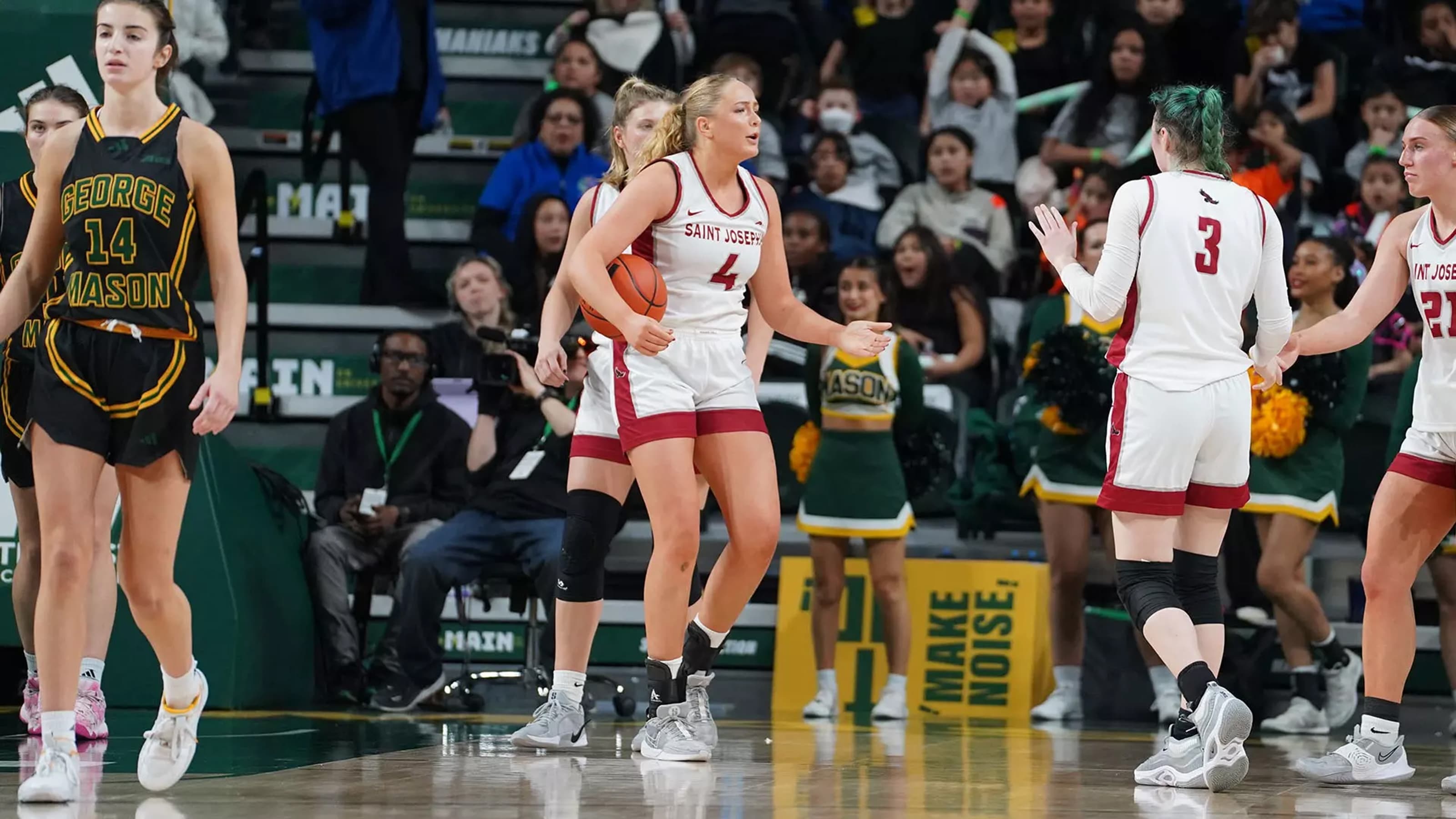 Laura Ziegler holding basketball on court talking to opponent during the game