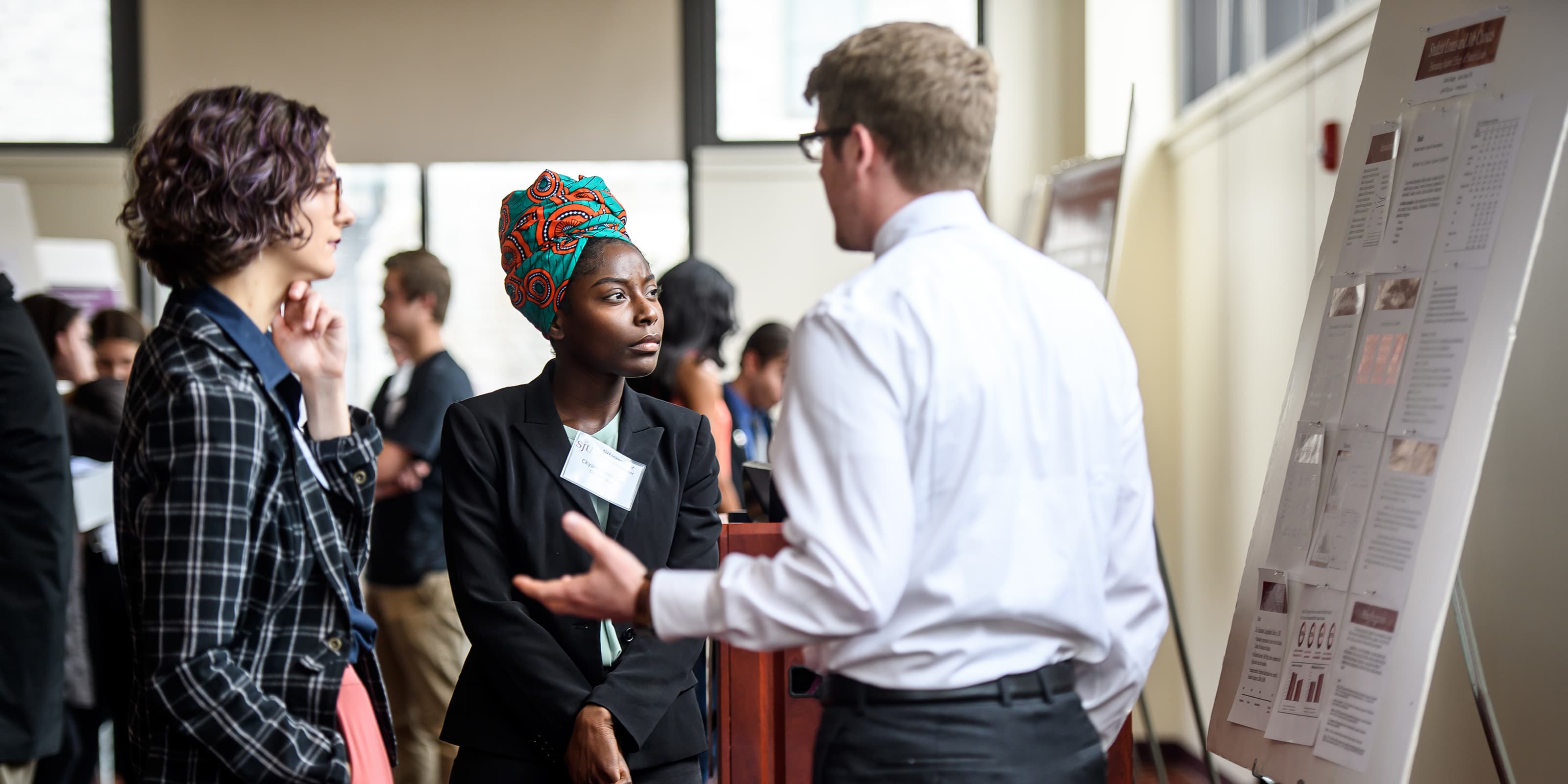 Two students hearing research presentation