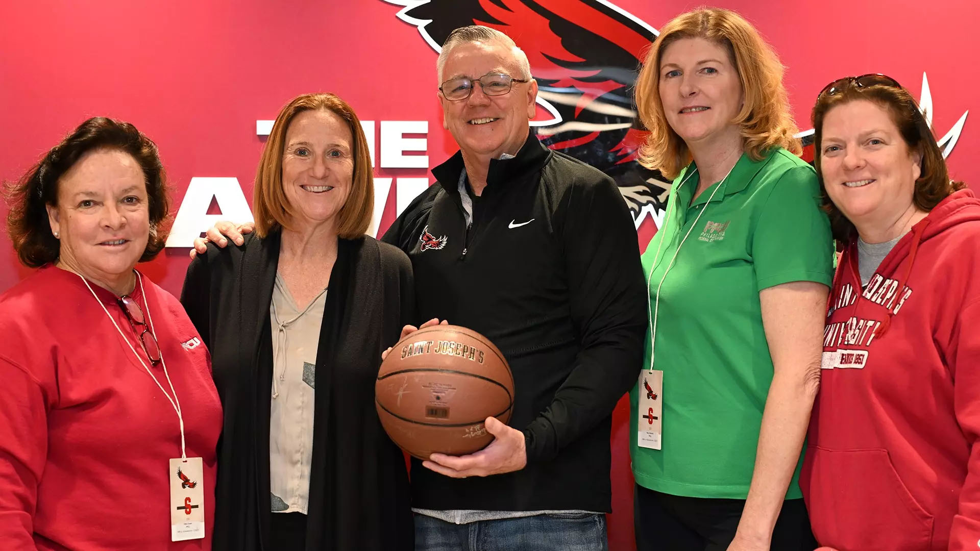 Four women and one man holding basketball in group photo for new Saint Joseph's and PFCU partnership