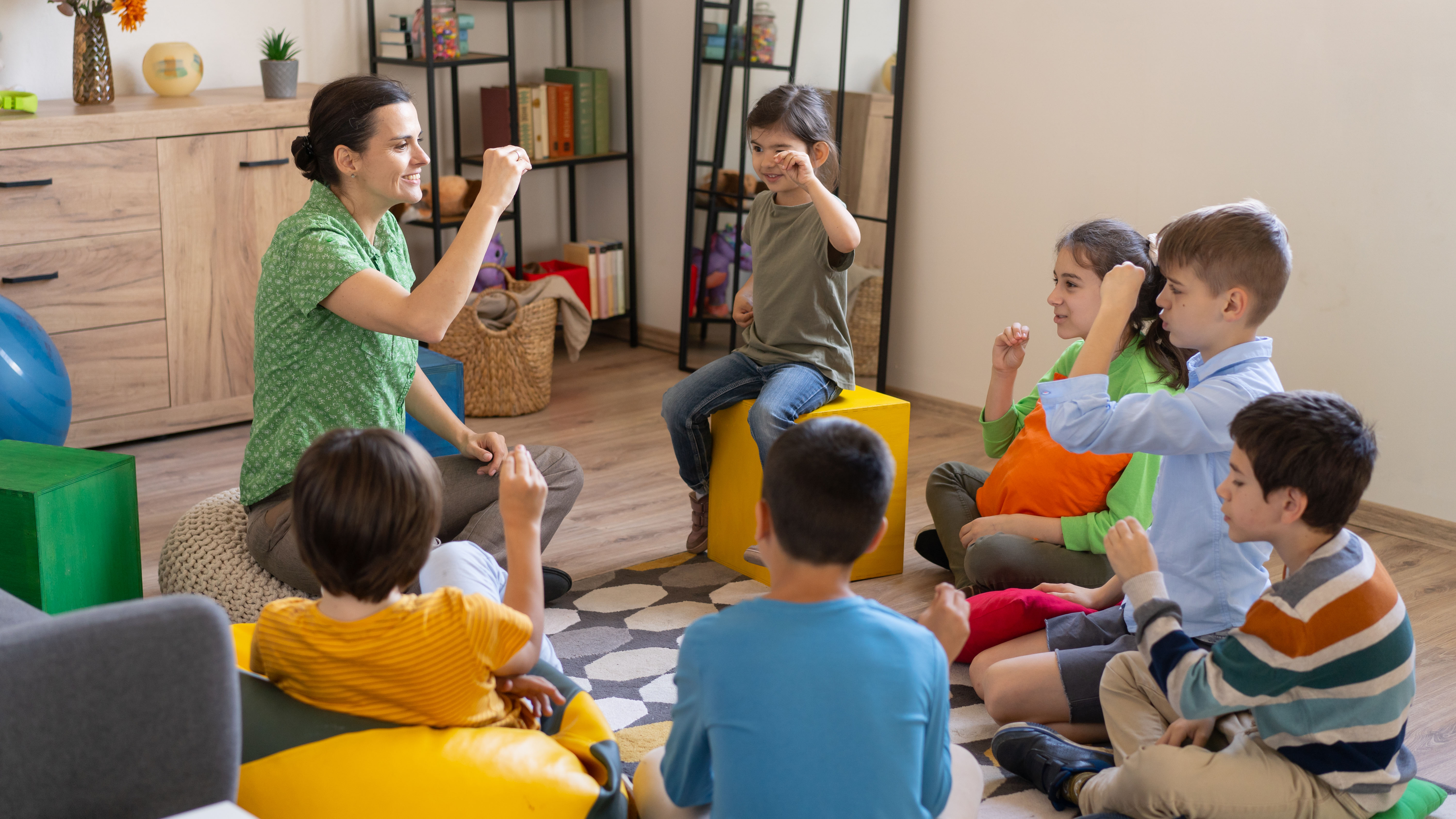 female sign language teacher teaching group of children in class