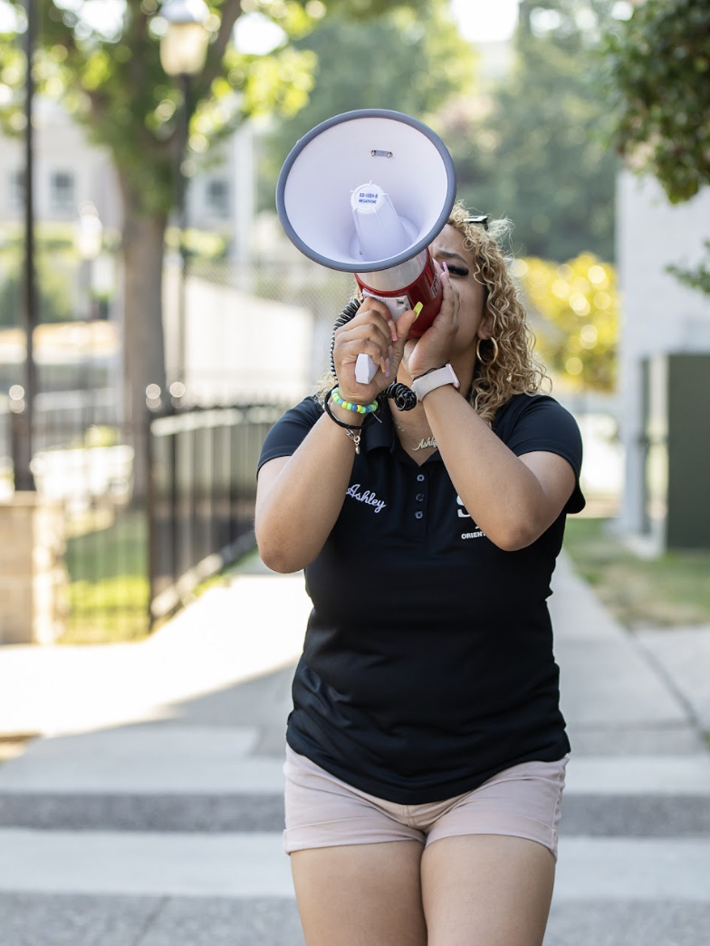 Ashley Morales speaking into blow horn at Saint Joseph's orientation