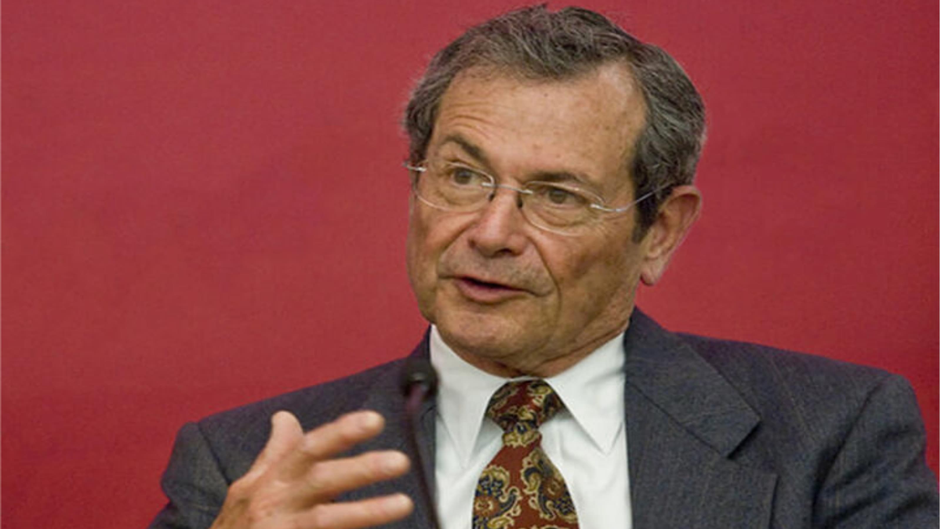 Allen Misher, BS ’59, PhD, H ’95 speaking in front of a red background.