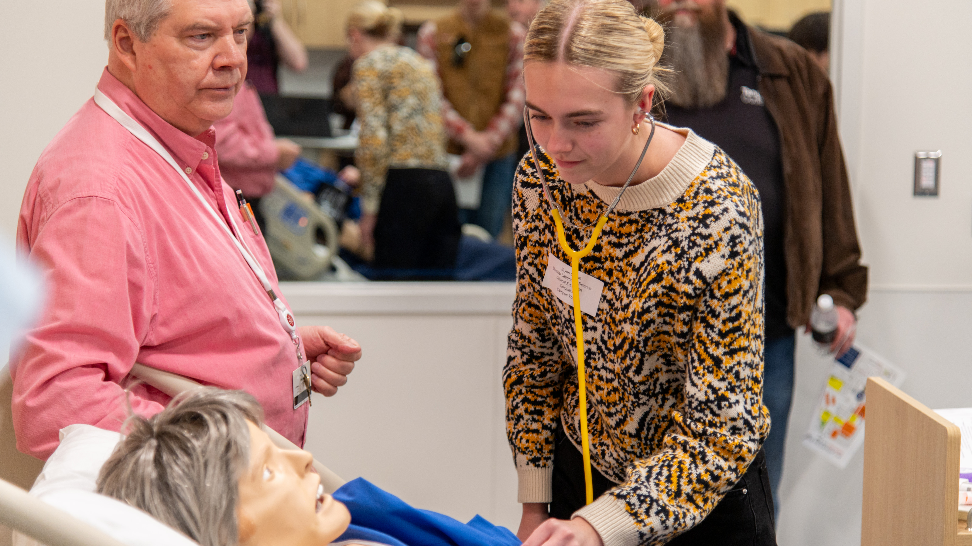 Student practices using a stethoscope on one of Saint Joseph’s lifelike nursing manikins.