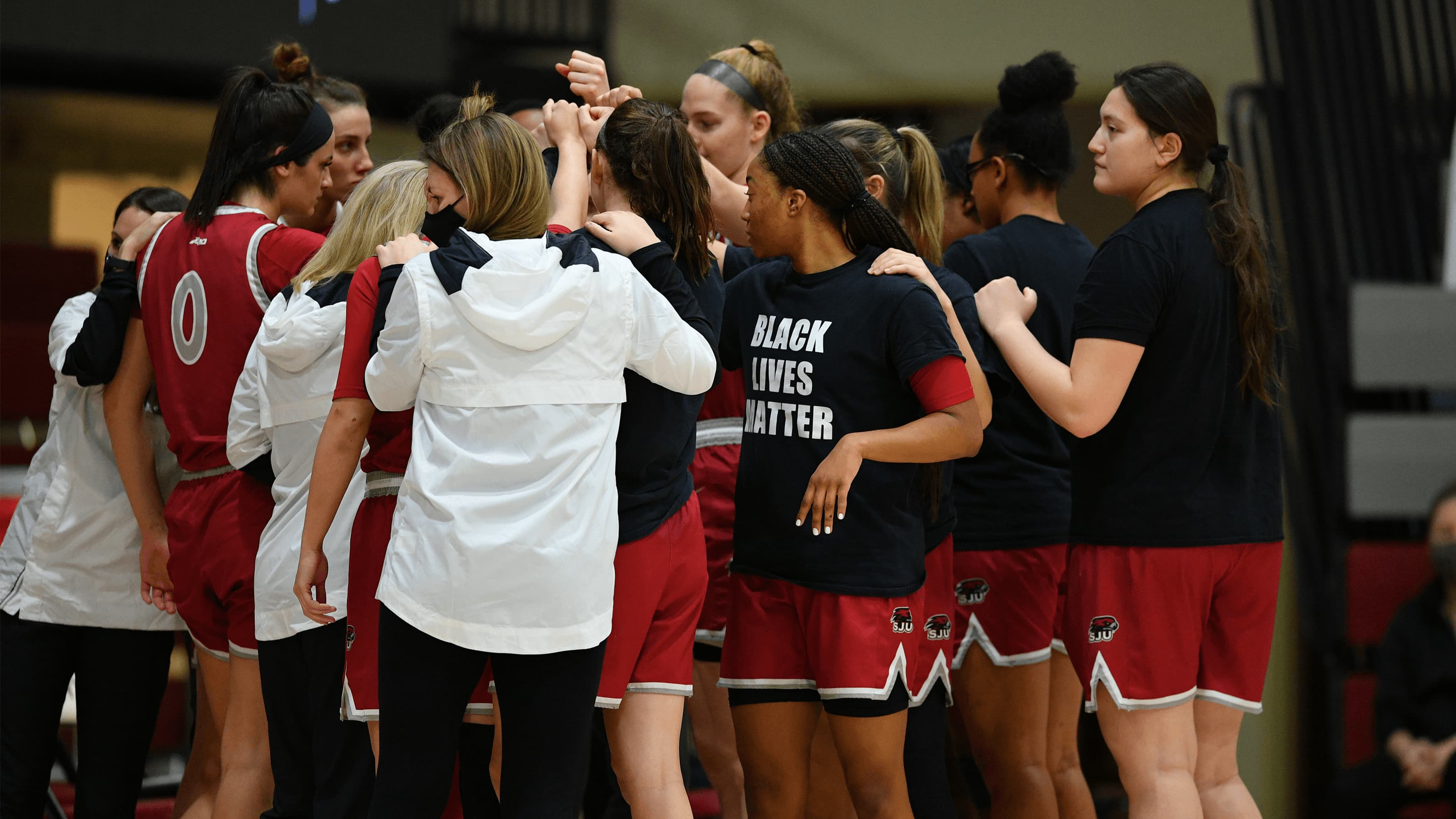 Saint Joseph's women's basketball team in a team huddle.