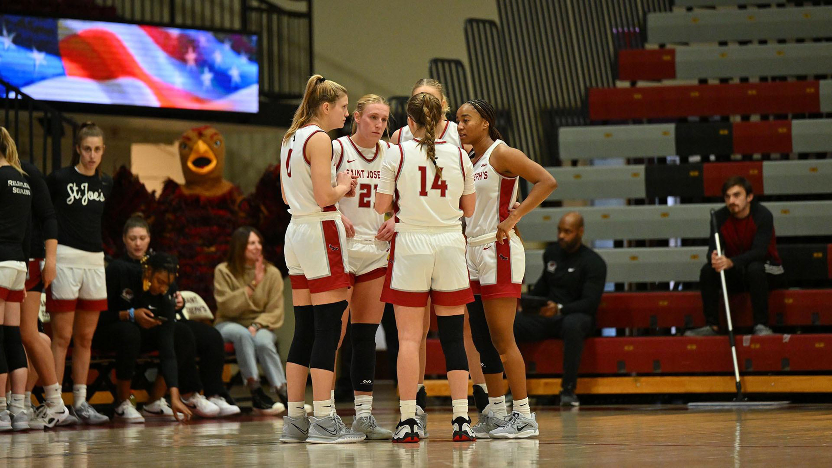 SJU Women's Basketball Team in a huddle on the court
