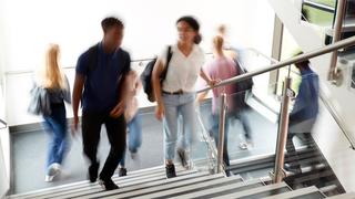 Motion blur shot of high school students walking on stairs between classes