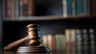 A gavel in front of a bookcase