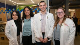 Four Philadelphia College of Pharmacy students and alumni in white lab coats at PCP Founders' Day Celebration