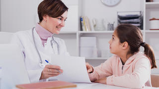 A doctor talks with a young patient
