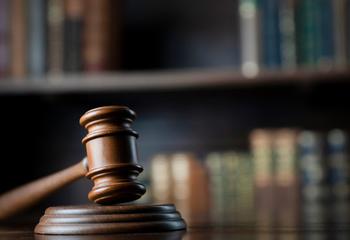 A gavel in front of a bookcase