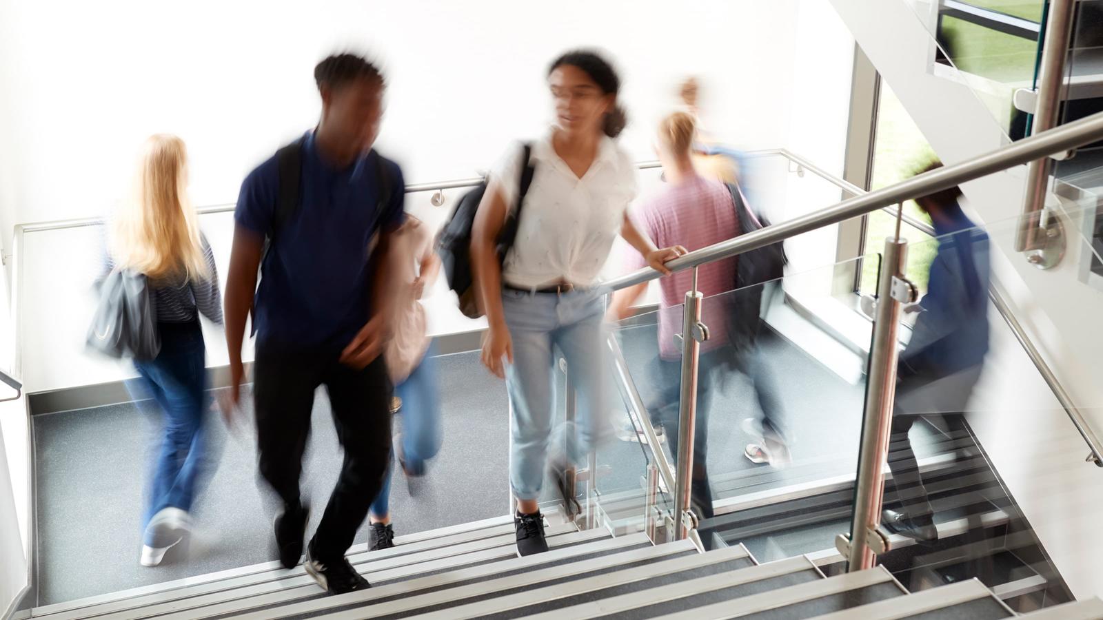 Group of individuals walking up stairs that is blurred