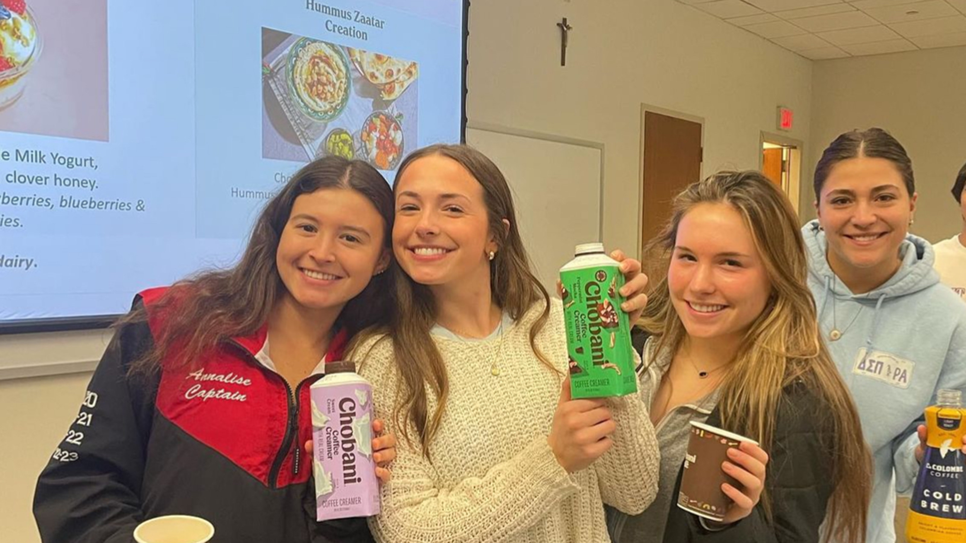 Food Marketing students holding cartons of Chobani creamer and La Colombe coffee