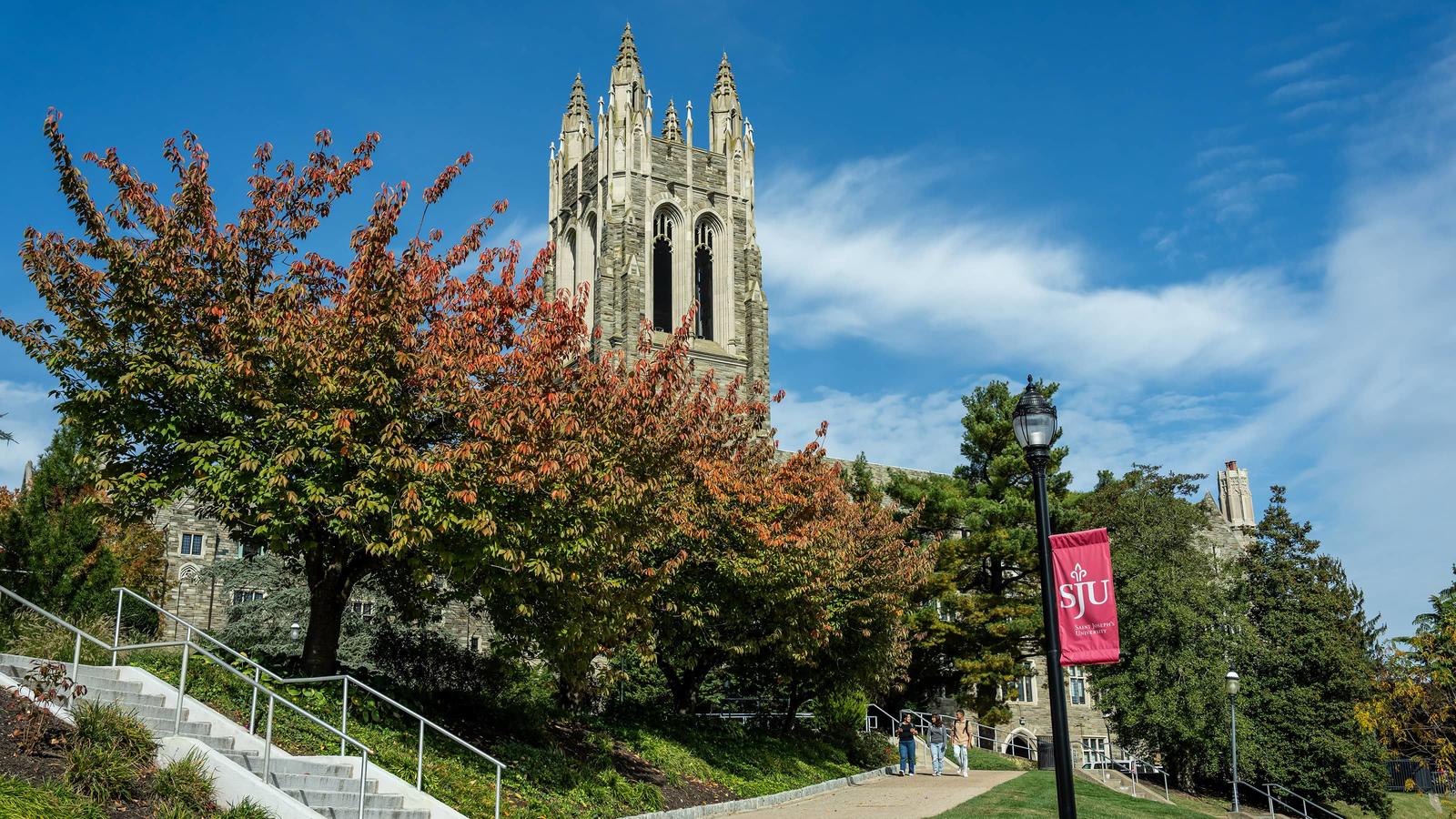 Saint Joseph's campus in fall with barbelin showing behind tree