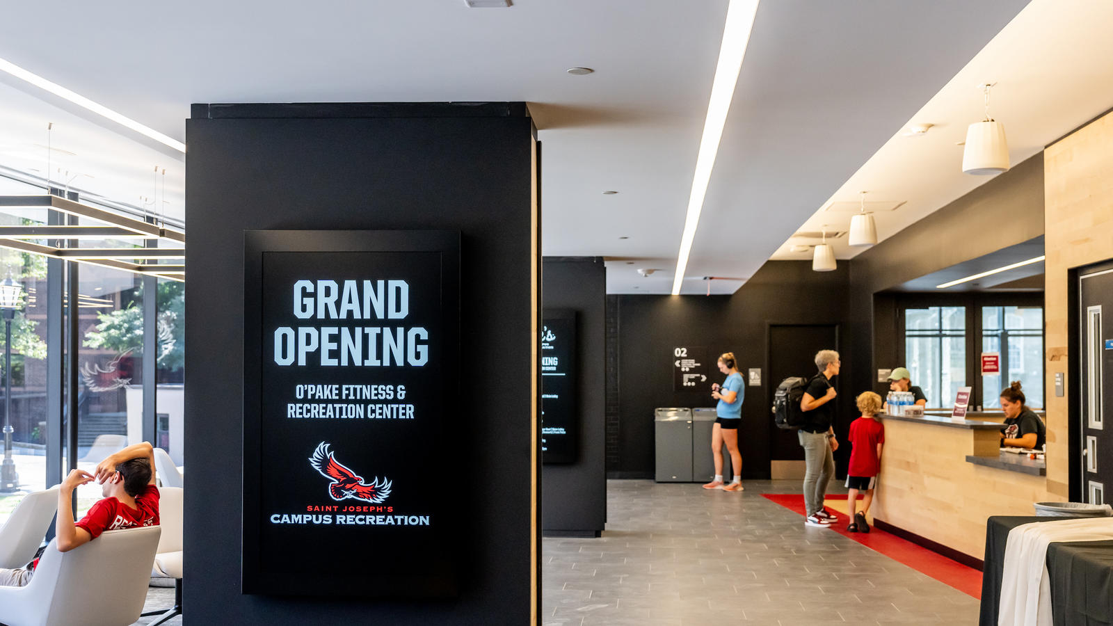 Entrance of O’Pake Fitness and Recreation Center with people standing around and welcome sign