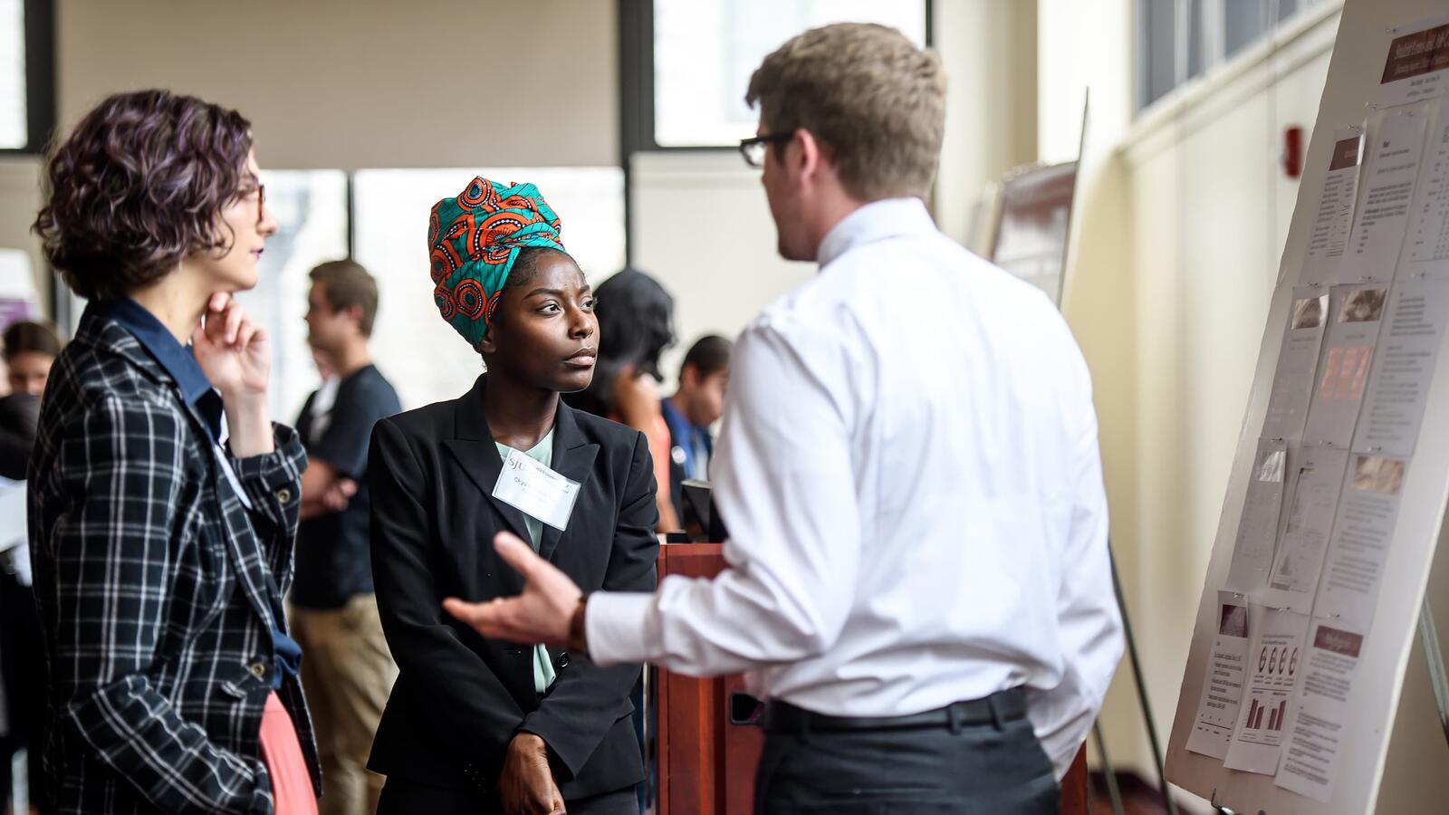 Two students hearing research presentation