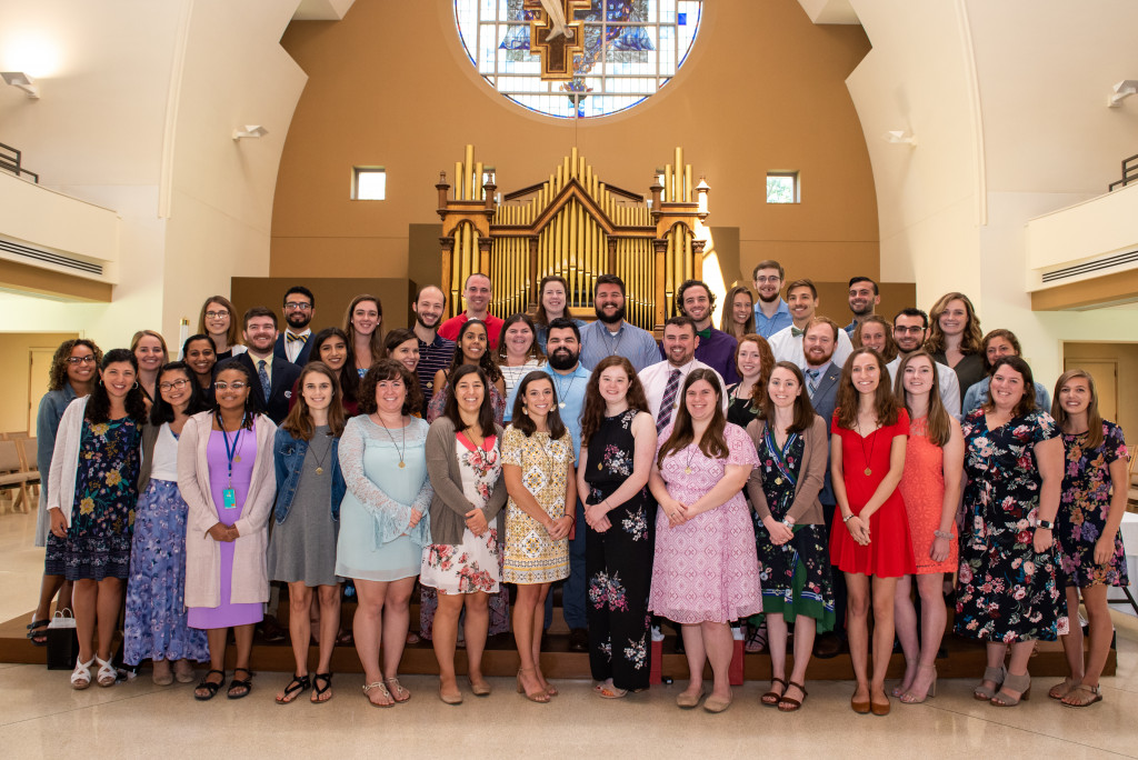 a group of students standing together for a group photo inside a church chapel