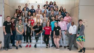 A group of students and faculty gathered together on the stairs