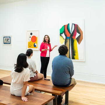 Museum educator teaching group of students in Maguire Museum at Saint Joseph's University