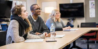 three saint joseph's university students in a classroom