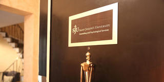 A door with a plaque reading "Saint Joseph's University Counseling and Psychological Services"
