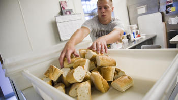 A student helping serve food at a food kitchen