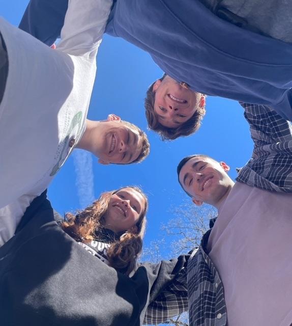 young people in a circle with arms around each other